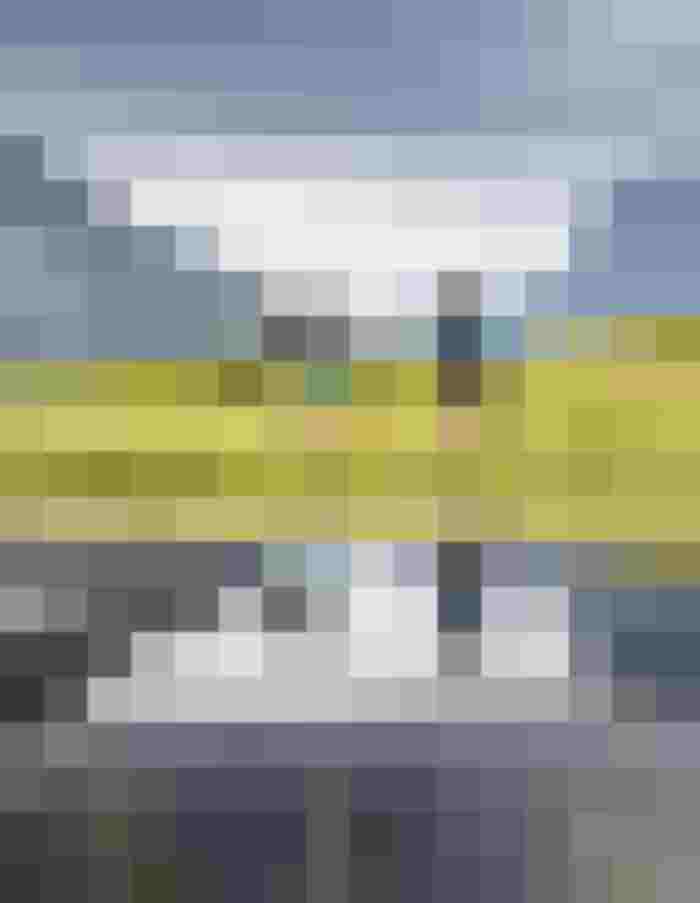 Wanderer erkunden eine alpine Landschaft mit spiegelndem Wasser und Bergen im Hintergrund.