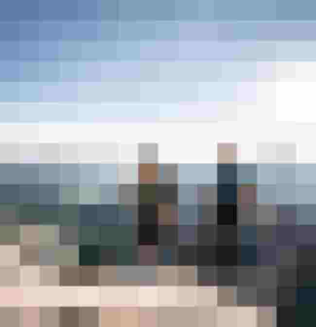 Kletterer auf dem Gipfel der Alpen mit Aussicht auf die umliegenden Berge.